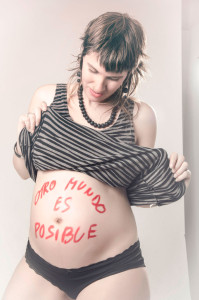 Laura embarazada con la inscripcion de otro mundo es posible. Fotografía de Milena Martínez, fotógrafa en Madrid
